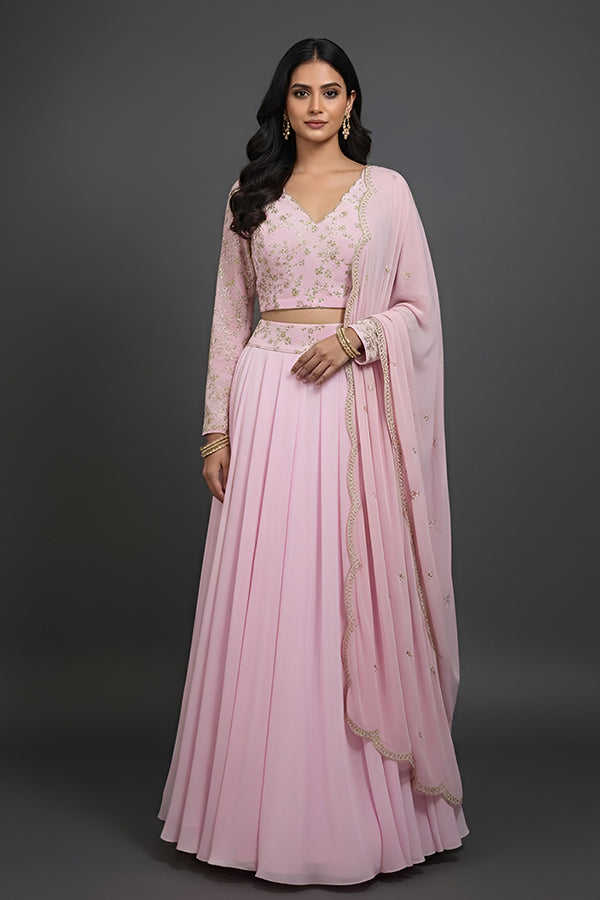 Woman wearing a pink traditional outfit with a matching dupatta on a gray background